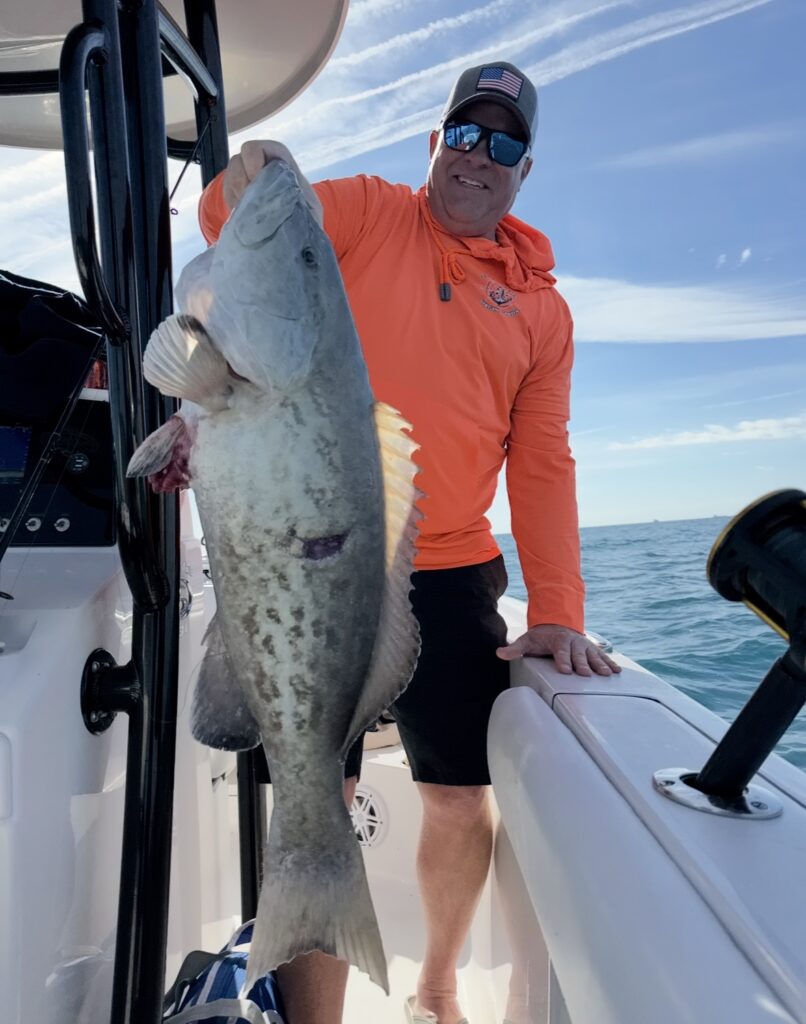 Deep sea fishing success - angler holding large grouper catch near St. Pete Beach Florida